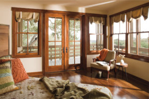 A bedroom with wooden floors and a large window.